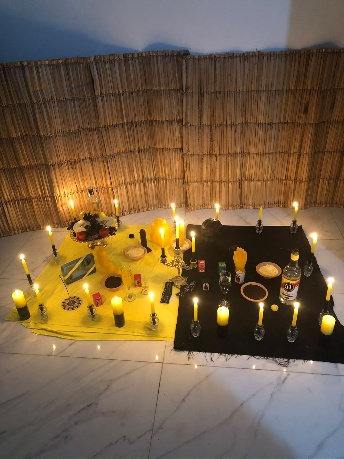 Montagem ritual com velas e tecidos amarelo e preto