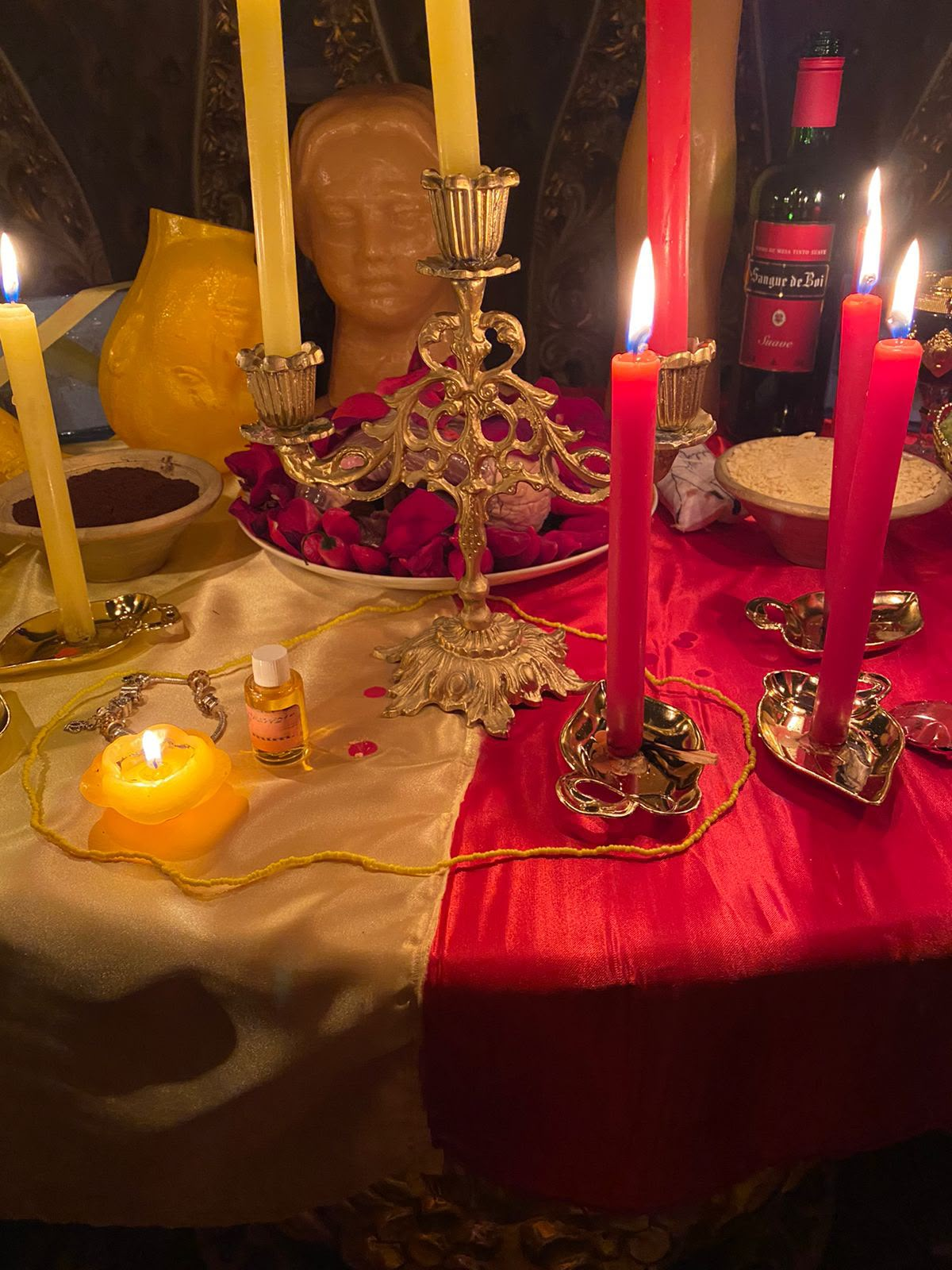 Mesa ritual com velas vermelhas e amarelas