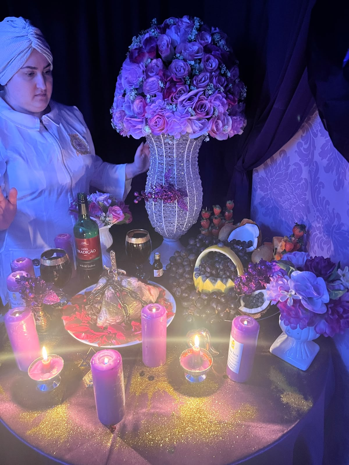 Paloma em altar com flores roxas e velas